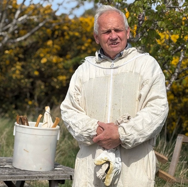 Jonathan Caddy in beekeeping clothes